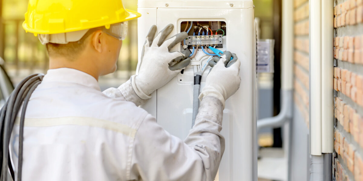 The air conditioner technician is checking the air compressor system.